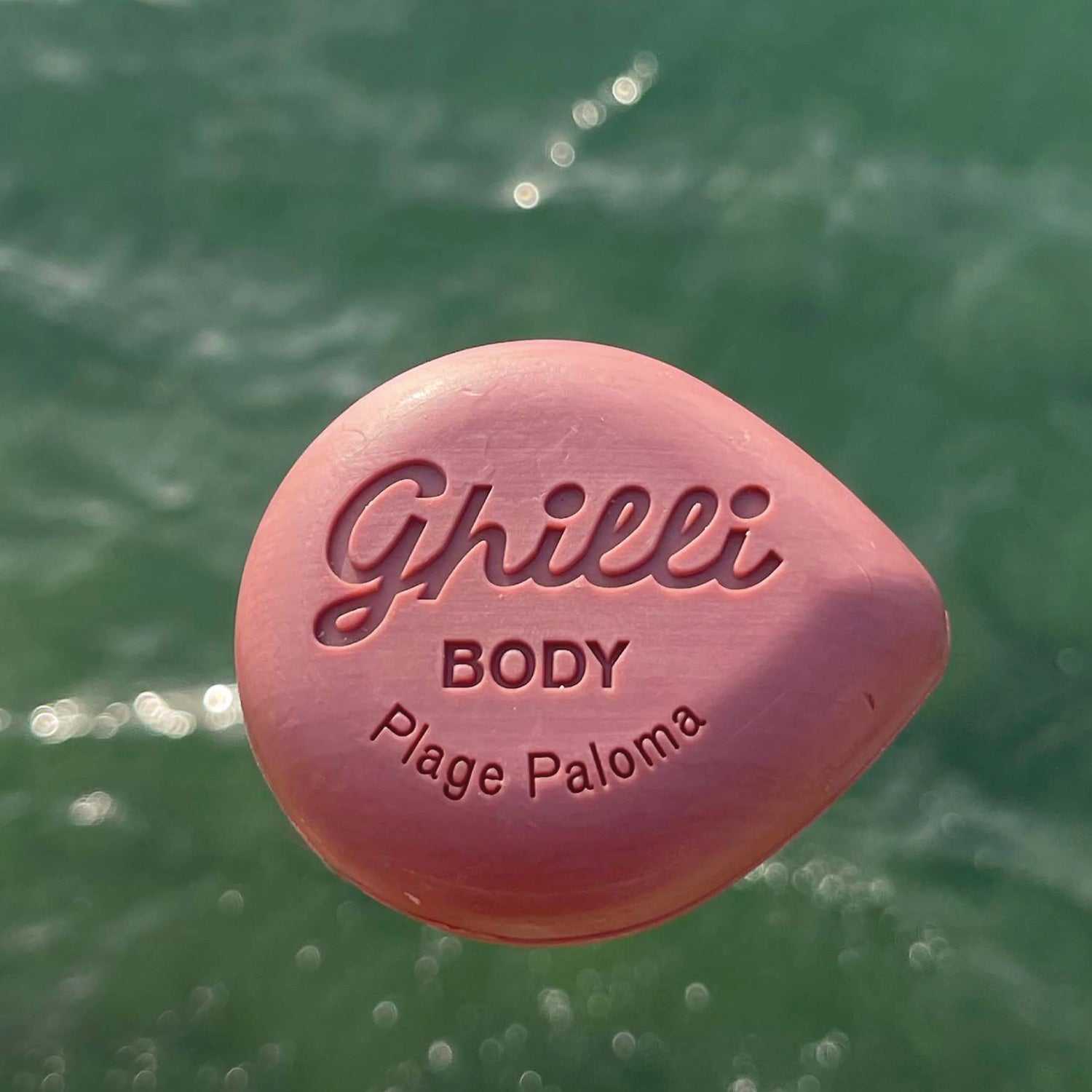 Rosa Ghilli Body Bar Plage Paloma mit Gravur vor Wasserkulisse, sanfte Reinigung und sinnlicher Duft.