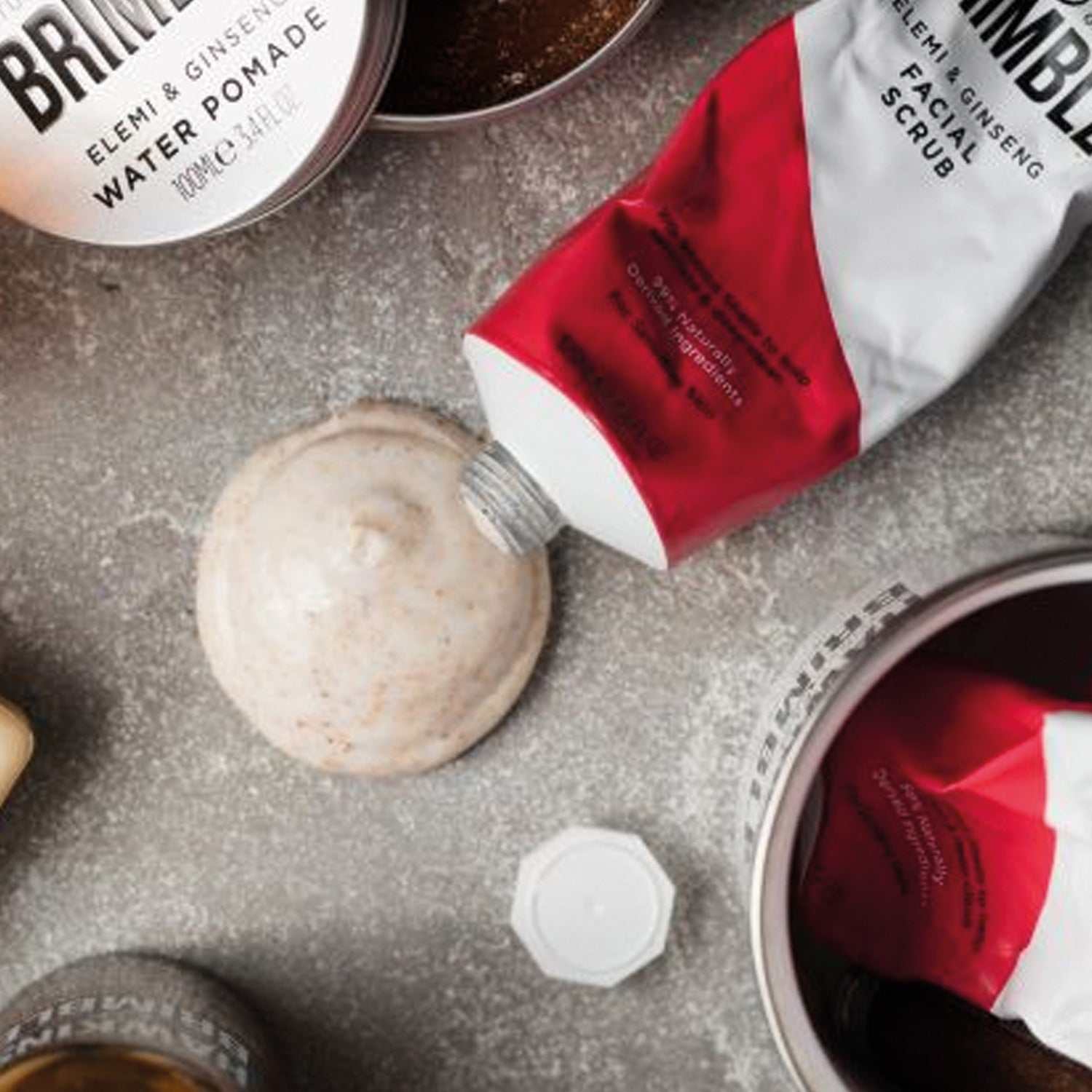 Gesichtspeeling Hawkins & Brimble in Tube mit natürlichem Peelingmittel auf grauem Hintergrund