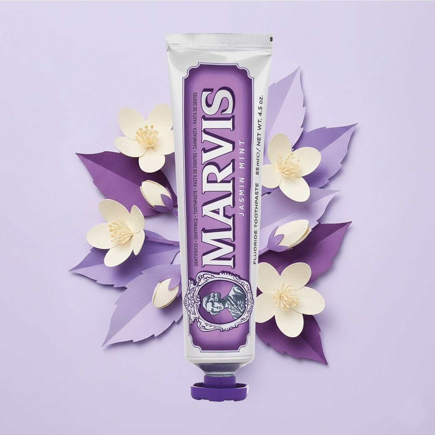 Marvis Zahnpasta Jasmin Mint mit blumigem Jasmin- und frischem Minzgeschmack vor lila Hintergrund mit Papierblumen