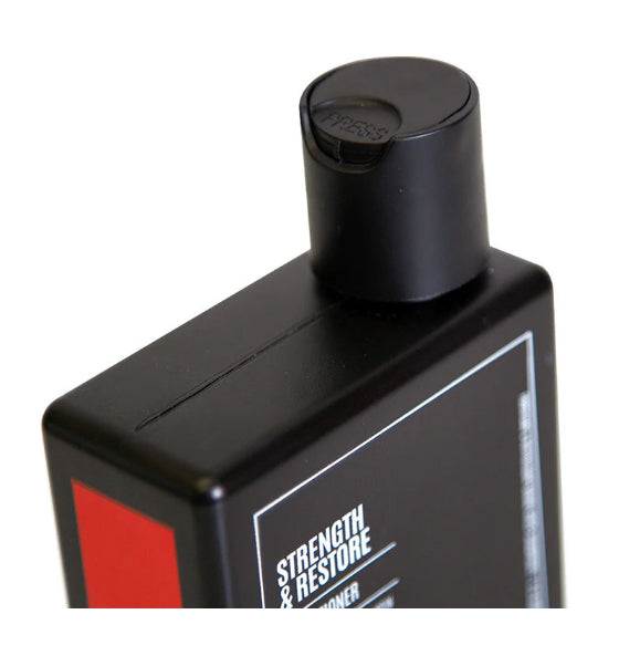 Schwarze Flasche des Uppercut Deluxe Strength and Restore Conditioners zur Stärkung und Regeneration von Haar mit Biotin und Koffein