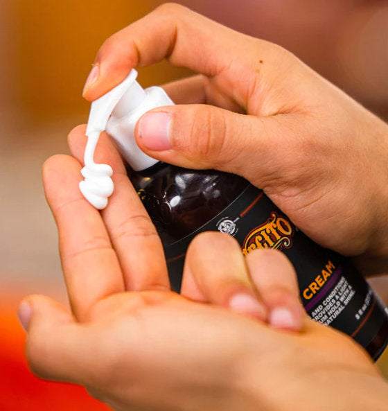 Hand trägt Suavecito Hair Creme auf, cremige Styling-Creme für flexiblen Halt und Glanz im Haar