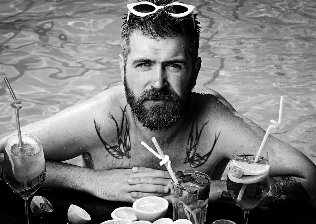 Bild mit einem bärtigen Mann im Pool zum Blogartikel Bartpflege im Sommer