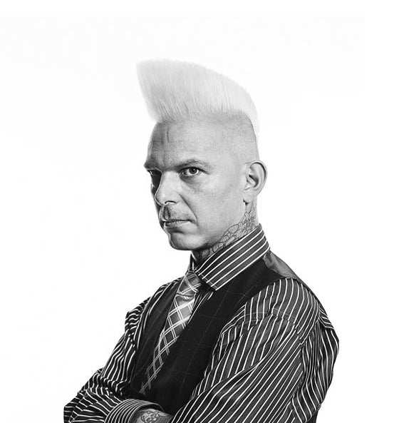 Mann mit markantem Haarschnitt präsentiert Aftershave Lotion - Reuzel für erfrischte und gepflegte Haut nach der Rasur